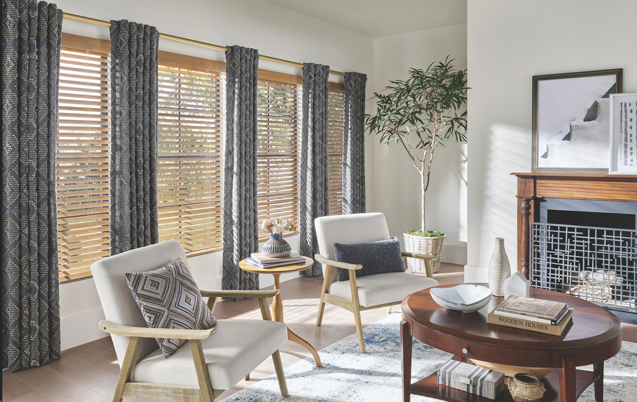 Patterned drapery panels with wood blinds in a living room