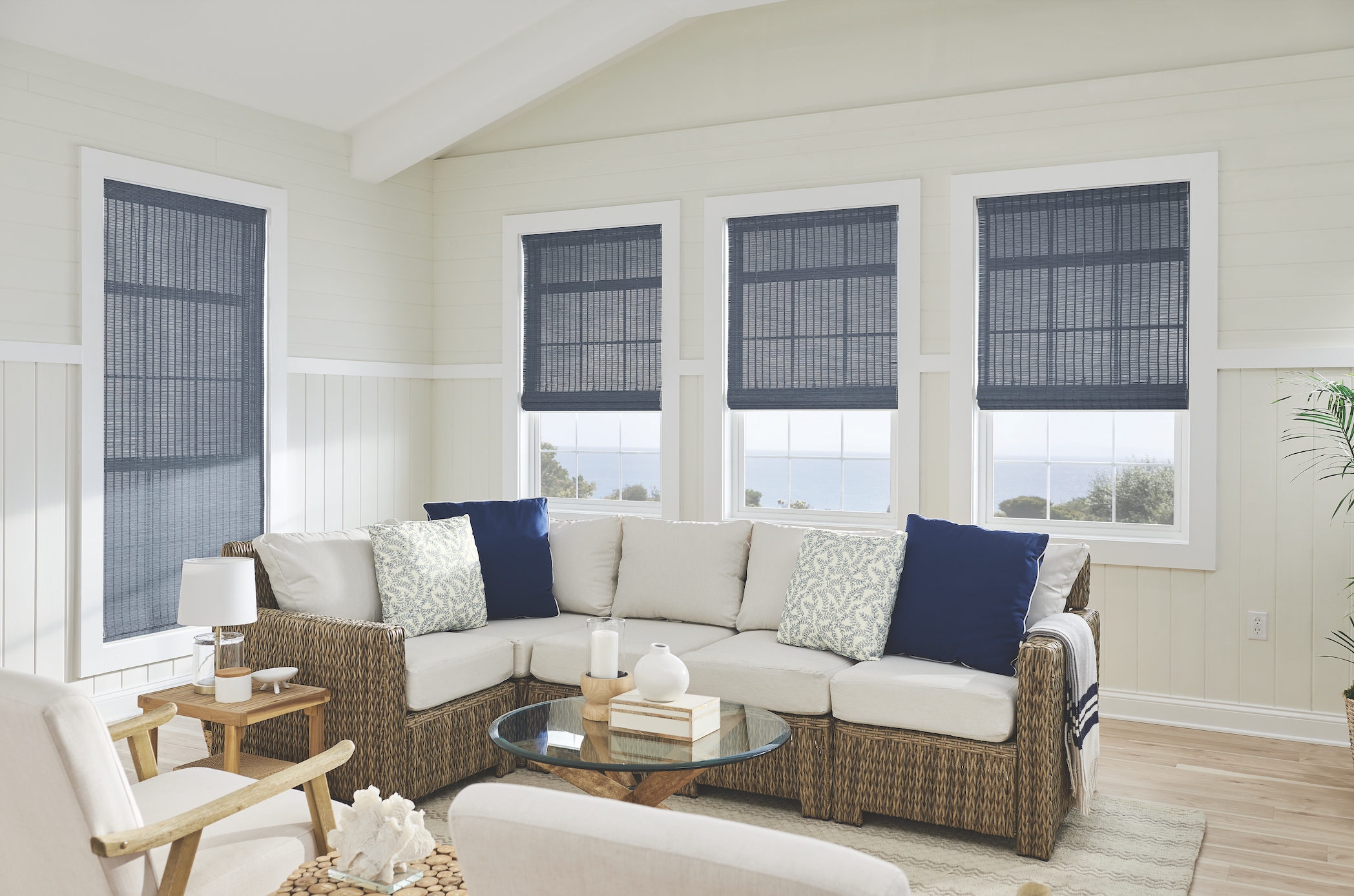 Navy woven natural shades in a coastal sunroom