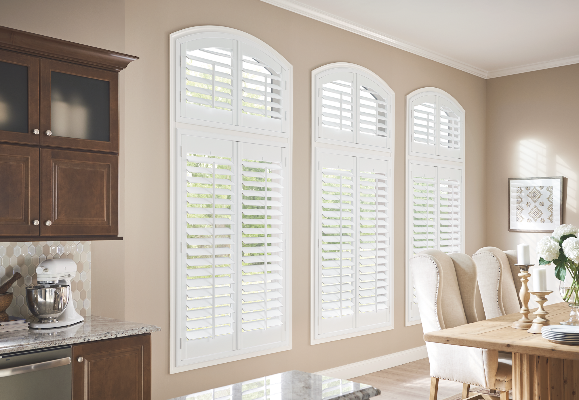 White shutters on arched windows in a kitchen